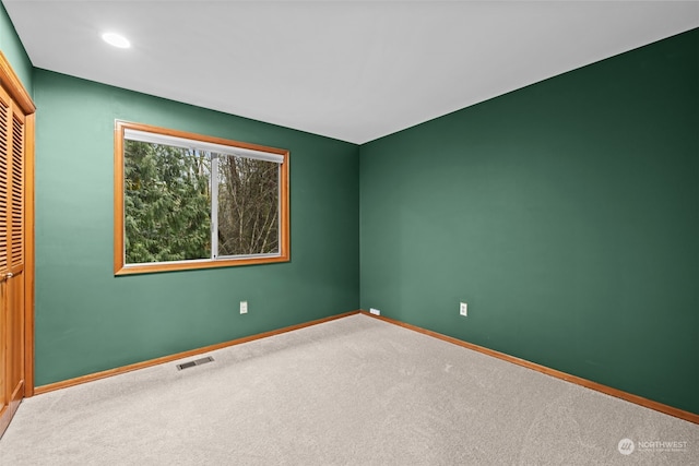 carpeted spare room featuring recessed lighting, visible vents, and baseboards