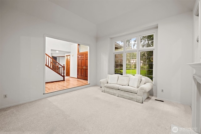 living room with carpet, stairs, visible vents, and a fireplace