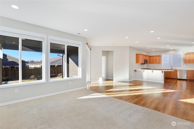 unfurnished living room featuring sink and light wood-type flooring