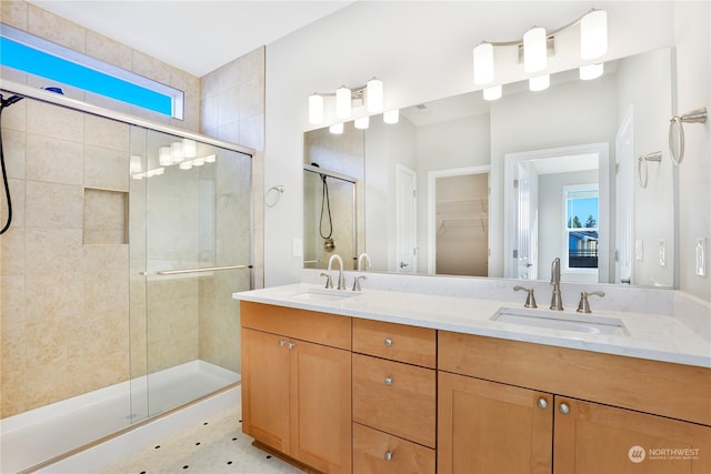 bathroom featuring a shower with door and vanity