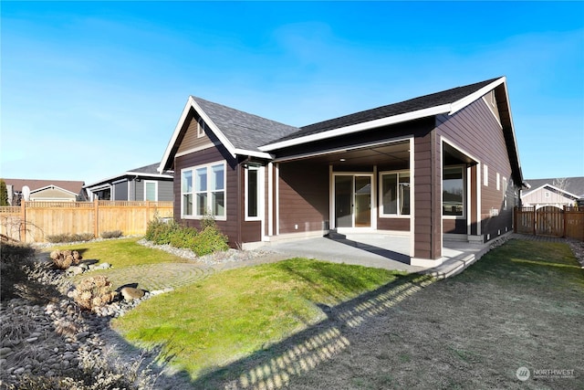 rear view of house with a patio area and a lawn