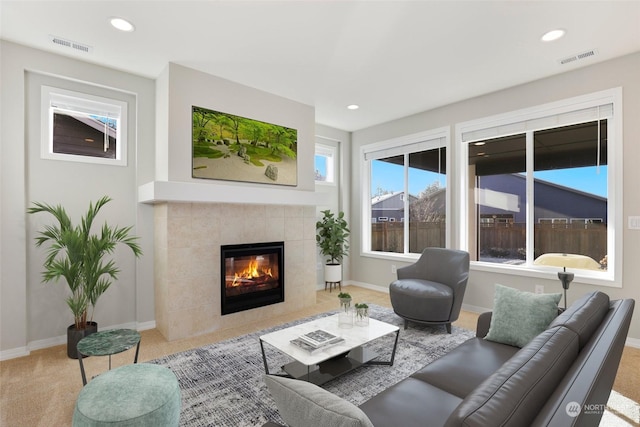 carpeted living room featuring a tile fireplace