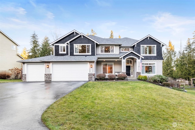 craftsman house featuring a garage and a front lawn