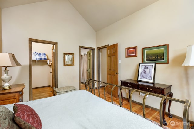 bedroom with hardwood / wood-style flooring and high vaulted ceiling