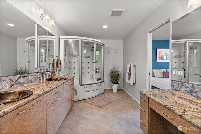 bathroom featuring tile patterned floors, vanity, and combined bath / shower with glass door