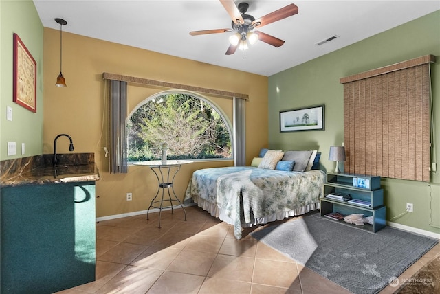 bedroom with ceiling fan, tile patterned floors, and sink