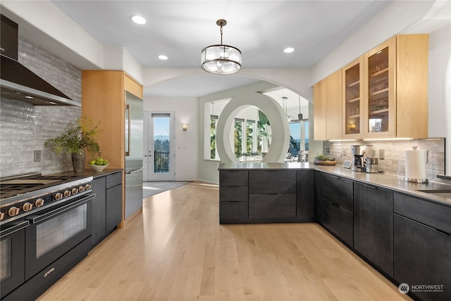 kitchen with hanging light fixtures, double oven range, light brown cabinetry, and wall chimney exhaust hood