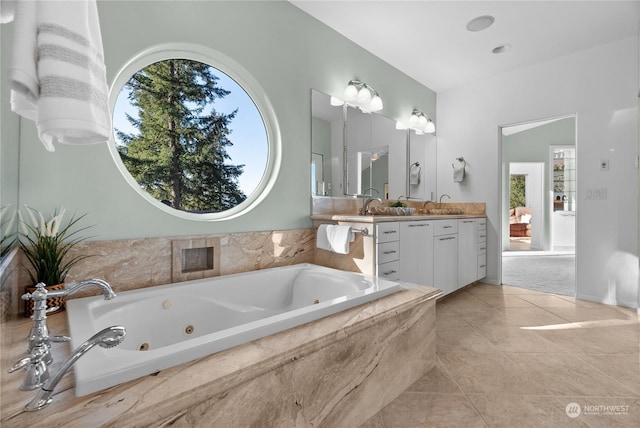 bathroom featuring tile patterned floors, vanity, a wealth of natural light, and tiled tub