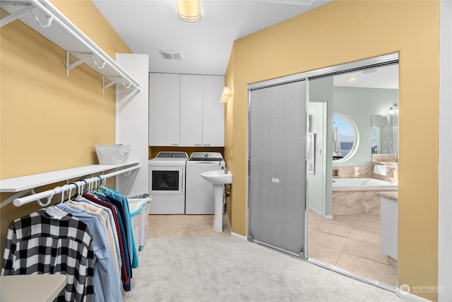 walk in closet with washing machine and dryer and light tile patterned floors