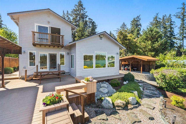 rear view of property featuring a balcony and a deck