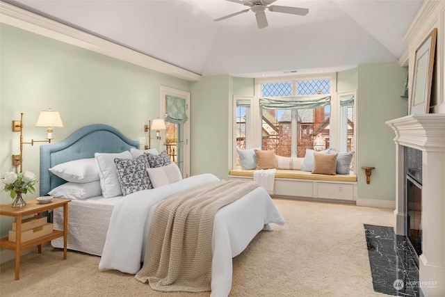 carpeted bedroom with ceiling fan, a high end fireplace, and vaulted ceiling