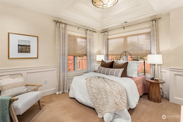 bedroom featuring light carpet and a tray ceiling