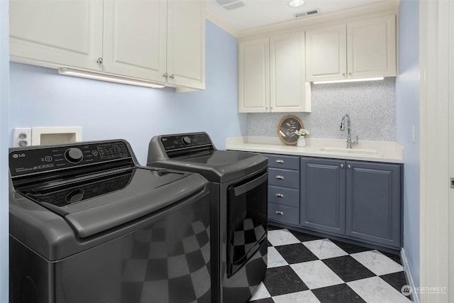 washroom featuring cabinets, sink, and washer and clothes dryer