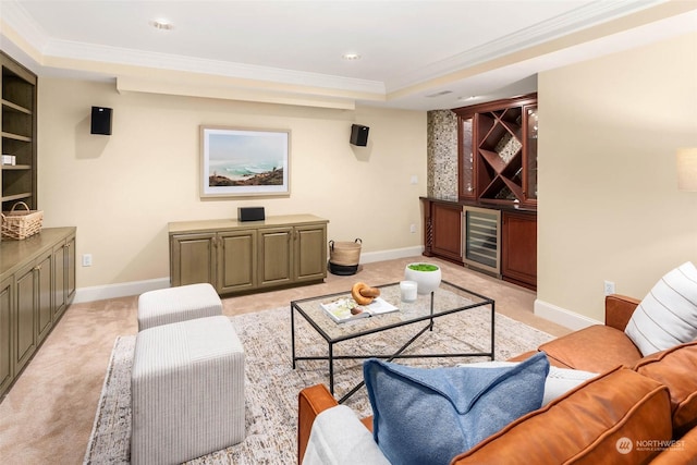 carpeted living room featuring ornamental molding, indoor bar, beverage cooler, and a tray ceiling