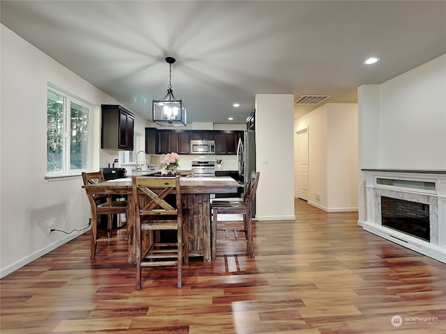 dining room featuring a fireplace, light hardwood / wood-style floors, and sink