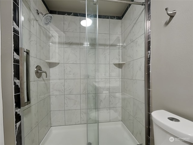 bathroom featuring an enclosed shower and toilet