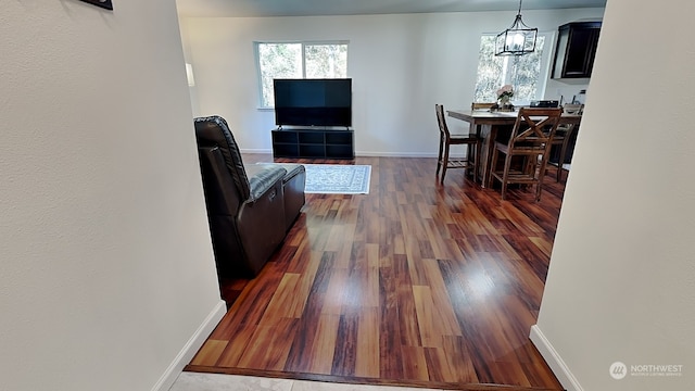 living room with dark hardwood / wood-style flooring and a chandelier