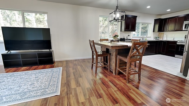 dining space with an inviting chandelier, wood-type flooring, and sink