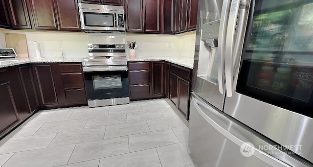 kitchen with light stone counters and appliances with stainless steel finishes