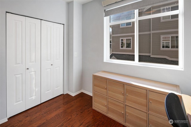 unfurnished bedroom with dark hardwood / wood-style flooring and a closet