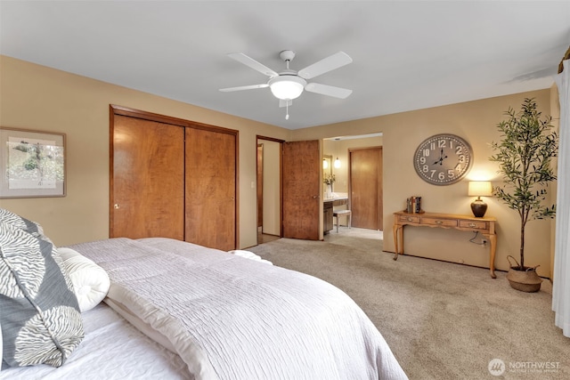 bedroom with light carpet, ceiling fan, and ensuite bath