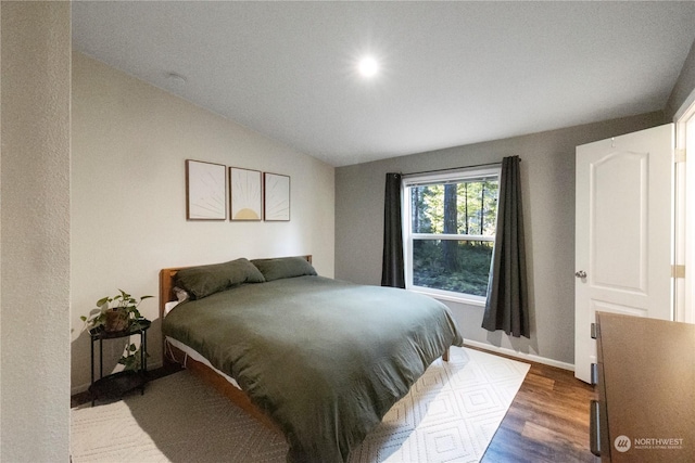 bedroom featuring vaulted ceiling and dark hardwood / wood-style flooring