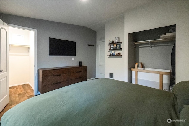 bedroom featuring wood-type flooring and vaulted ceiling