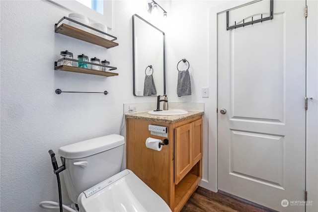 bathroom with vanity, hardwood / wood-style floors, and toilet