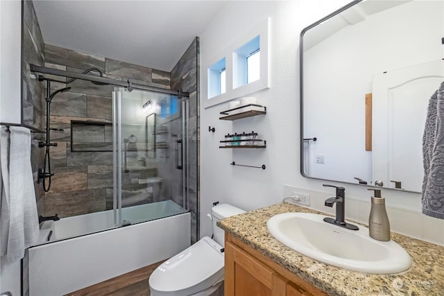 full bathroom featuring vanity, toilet, and combined bath / shower with glass door