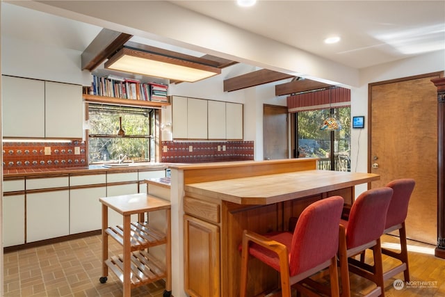 kitchen featuring a kitchen island, white cabinets, and decorative backsplash