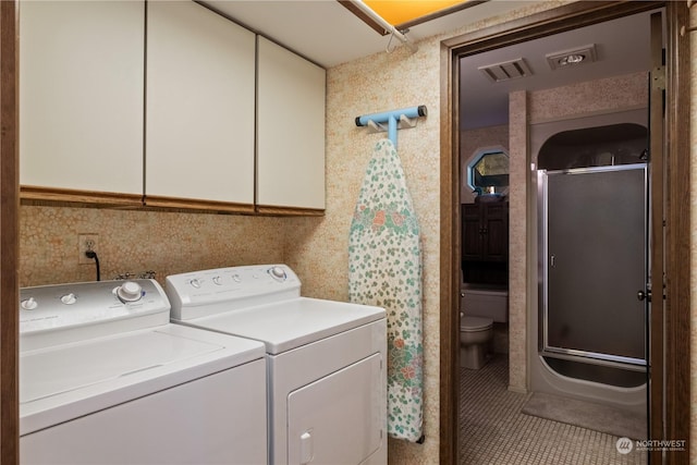 washroom featuring cabinets, separate washer and dryer, and tile patterned floors