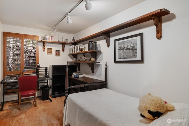 carpeted bedroom featuring track lighting