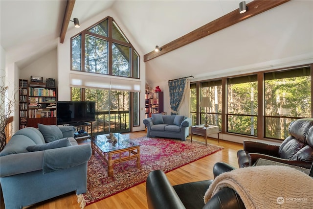 living room featuring hardwood / wood-style flooring, high vaulted ceiling, and beam ceiling