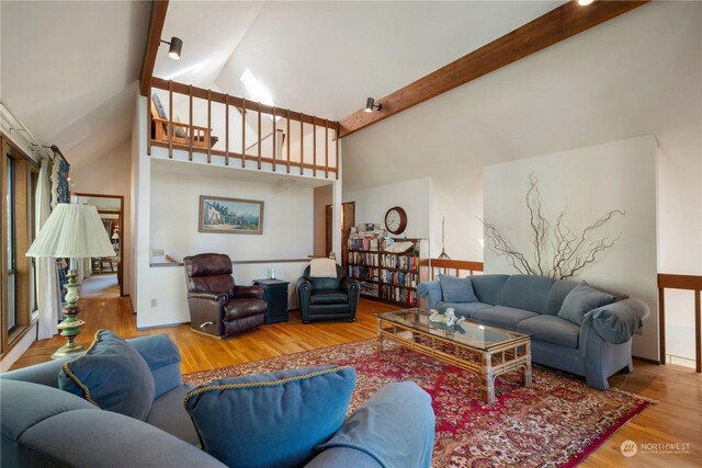 living room featuring beam ceiling, wood-type flooring, and high vaulted ceiling