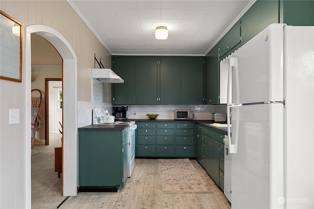 kitchen with green cabinetry, crown molding, white appliances, and decorative backsplash