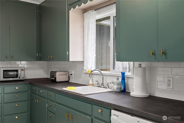 kitchen featuring sink, decorative backsplash, white dishwasher, and green cabinetry