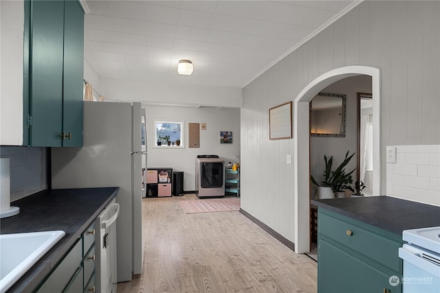 kitchen featuring sink, light hardwood / wood-style flooring, dishwasher, ornamental molding, and washer / dryer