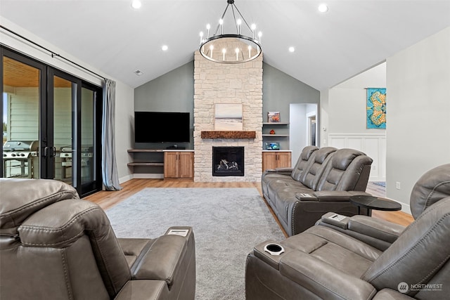 living room featuring french doors, an inviting chandelier, high vaulted ceiling, light hardwood / wood-style flooring, and a fireplace