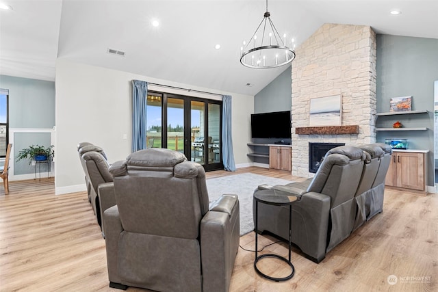 living room with a notable chandelier, a fireplace, french doors, and light wood-type flooring