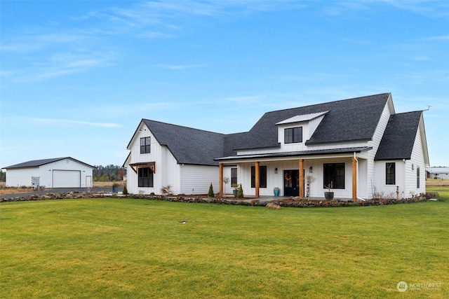 modern farmhouse style home with a garage, an outdoor structure, a porch, and a front yard