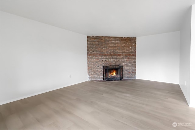 unfurnished living room with a fireplace and light wood-type flooring