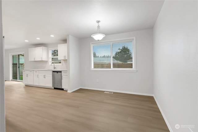 kitchen with dishwasher, hanging light fixtures, tasteful backsplash, white cabinets, and light wood-type flooring