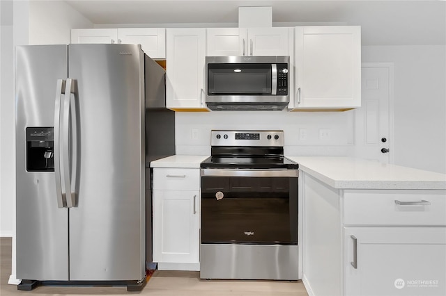 kitchen with white cabinetry, stainless steel appliances, and light hardwood / wood-style floors