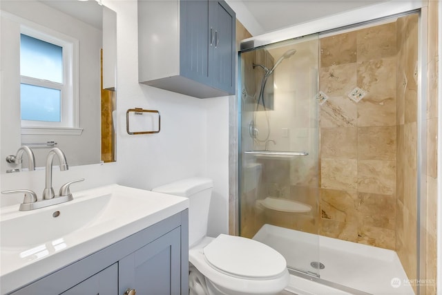 bathroom with vanity, toilet, and a shower with shower door