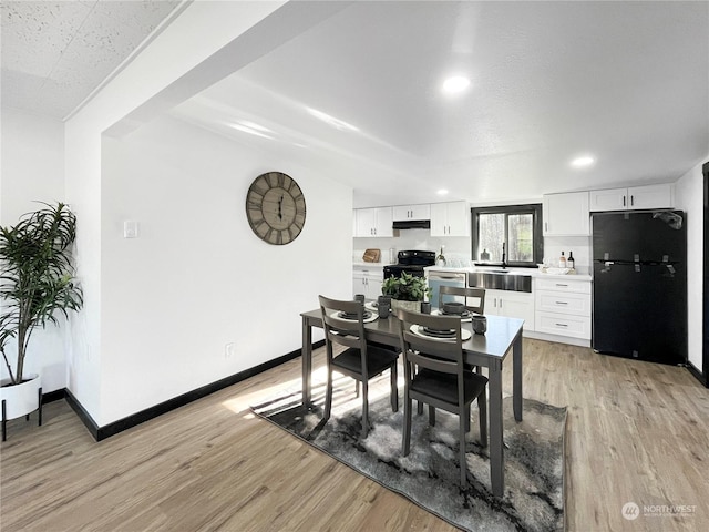 dining area featuring sink and light hardwood / wood-style flooring