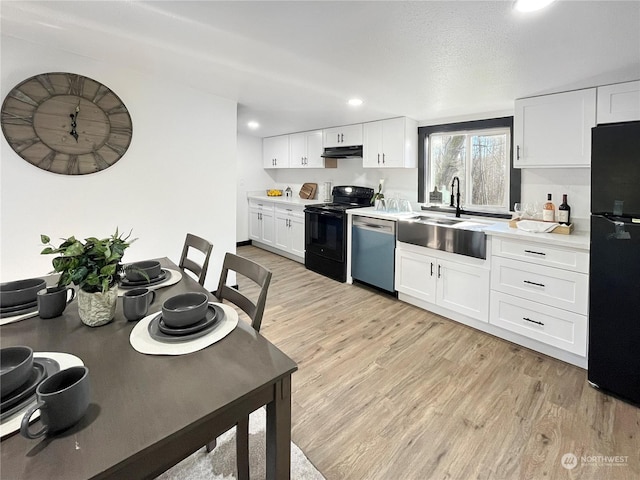 kitchen with white cabinetry, light wood-type flooring, sink, and black appliances