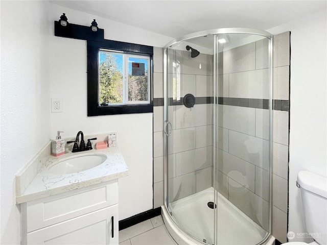 bathroom with tile patterned floors, vanity, toilet, and an enclosed shower