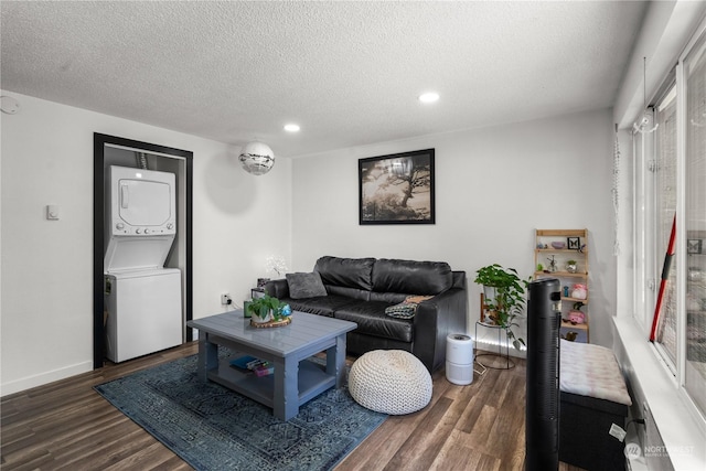 living room with stacked washer and clothes dryer, dark hardwood / wood-style floors, and a textured ceiling