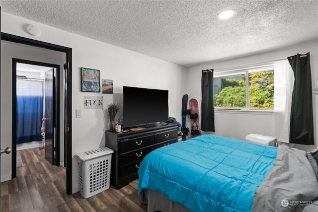 bedroom featuring dark hardwood / wood-style flooring and a textured ceiling