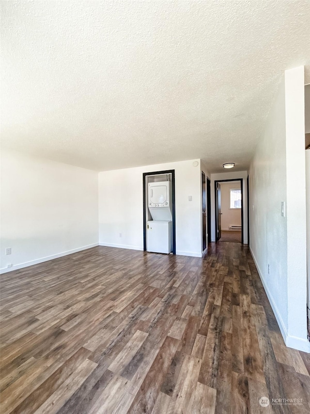 empty room with a baseboard radiator, dark hardwood / wood-style floors, and a textured ceiling